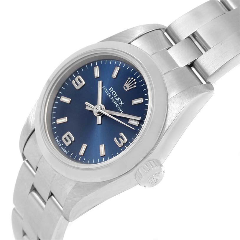 The image shows a tilted side view of a Rolex Oyster Perpetual 76080 Women
s Stainless Steel Blue Dial 76080 Women
s Stainless Steel Blue Dial watch, highlighting its dial, case, crown, and bracelet.