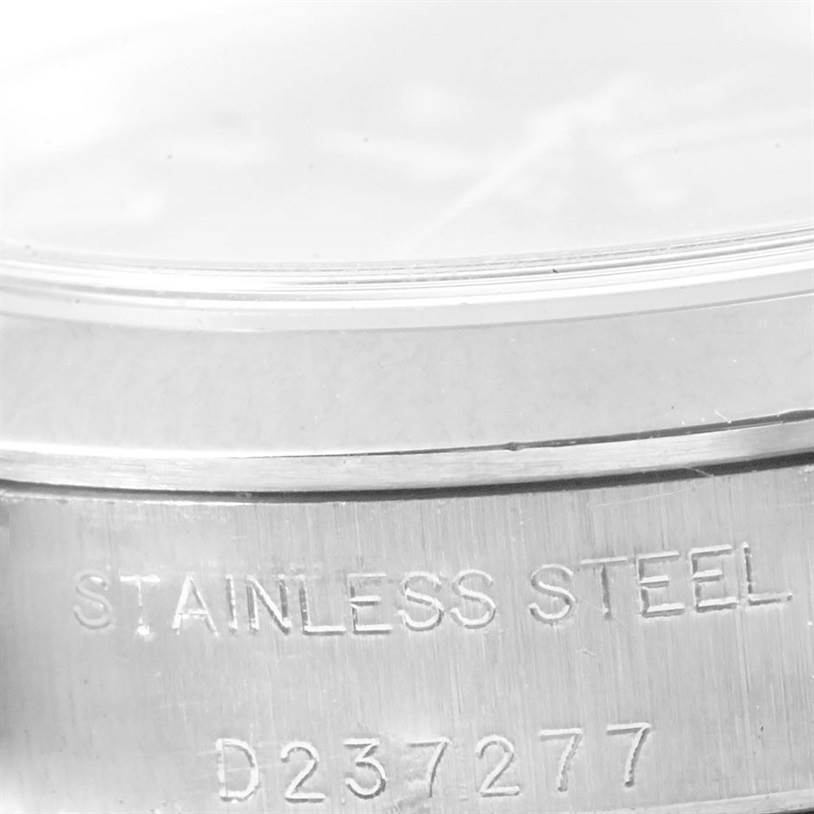 This image shows a close-up of the side of a Rolex Oyster Perpetual 76080 Women
s Stainless Steel Blue Dial 76080 Women
s Stainless Steel Blue Dial watch case with "STAINLESS STEEL" and serial number D237277 visible.