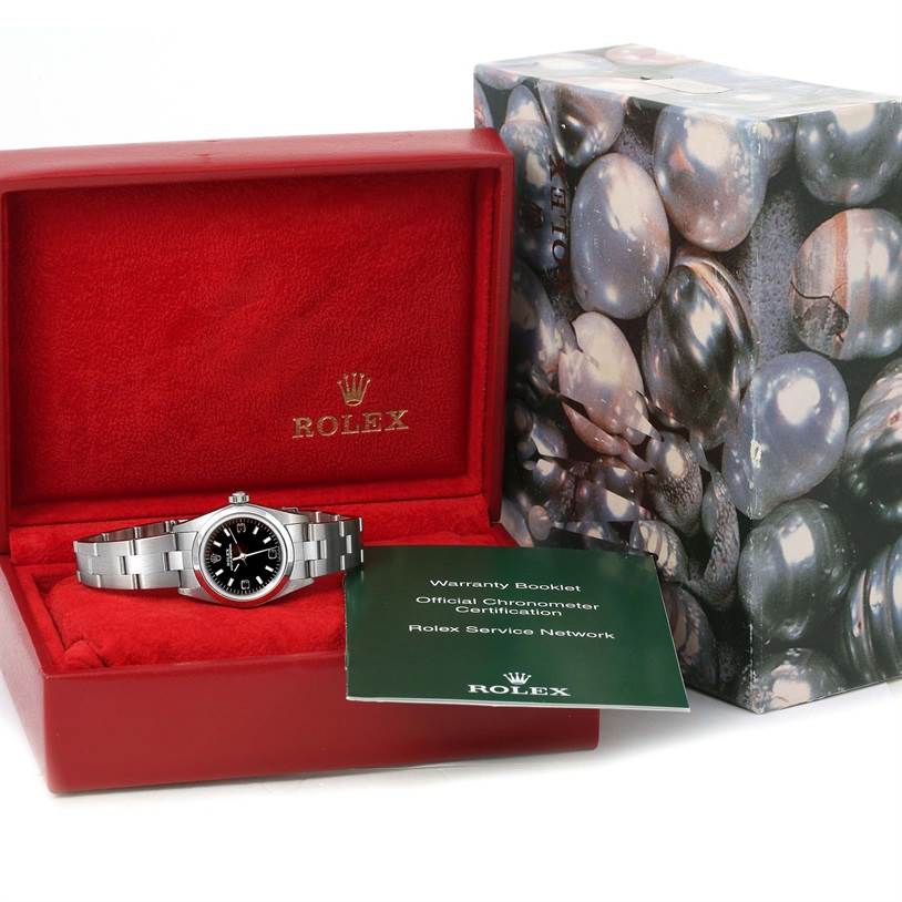 The image shows a Rolex Oyster Perpetual 76080 Women's Stainless Steel Black Dial 76080 Women's Stainless Steel Black Dial watch in a slightly open red box, accompanied by a warranty booklet and an outer packaging box.