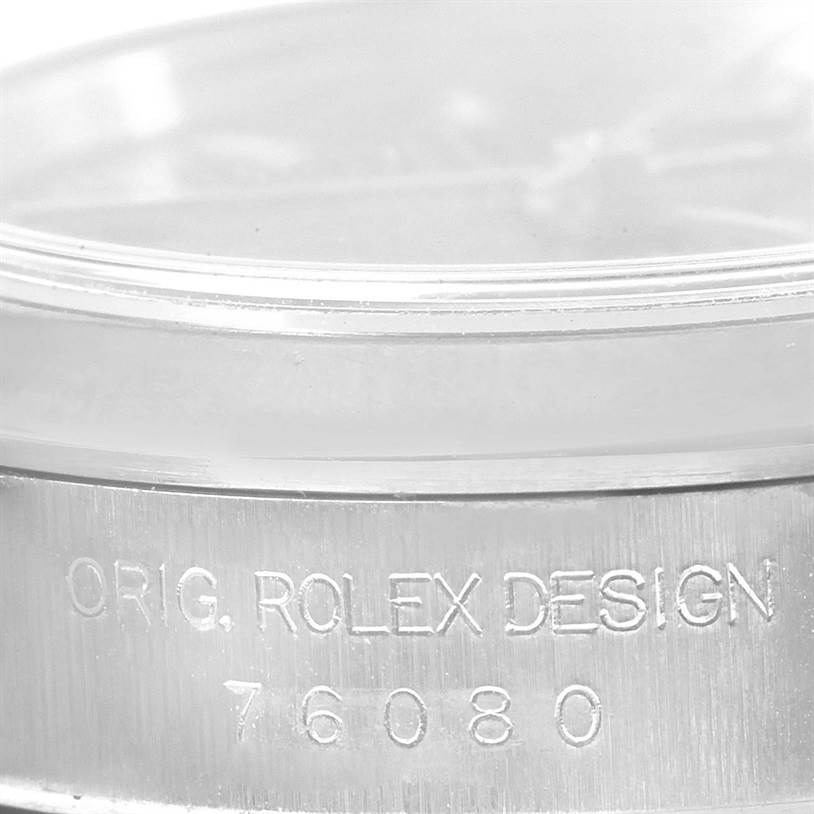 The image shows a close-up of the case side of a Rolex Oyster Perpetual 76080 Women's Stainless Steel Black Dial 76080 Women's Stainless Steel Black Dial watch, featuring the engraving "ORIG. ROLEX DESIGN 76080".