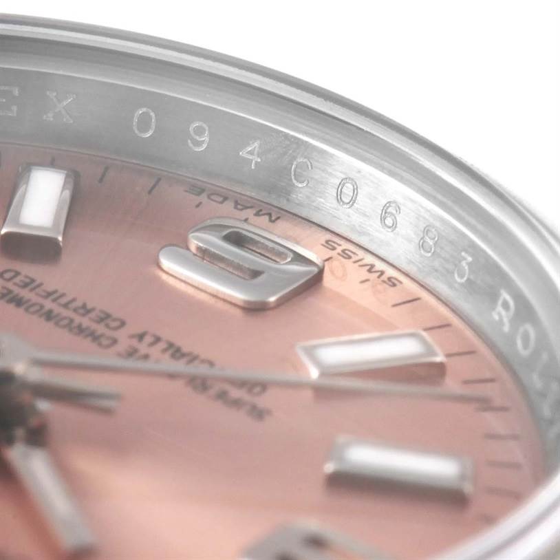 The image shows a close-up of the dial and bezel of an Oyster Perpetual Rolex, revealing parts of the numerals and text engraving.
