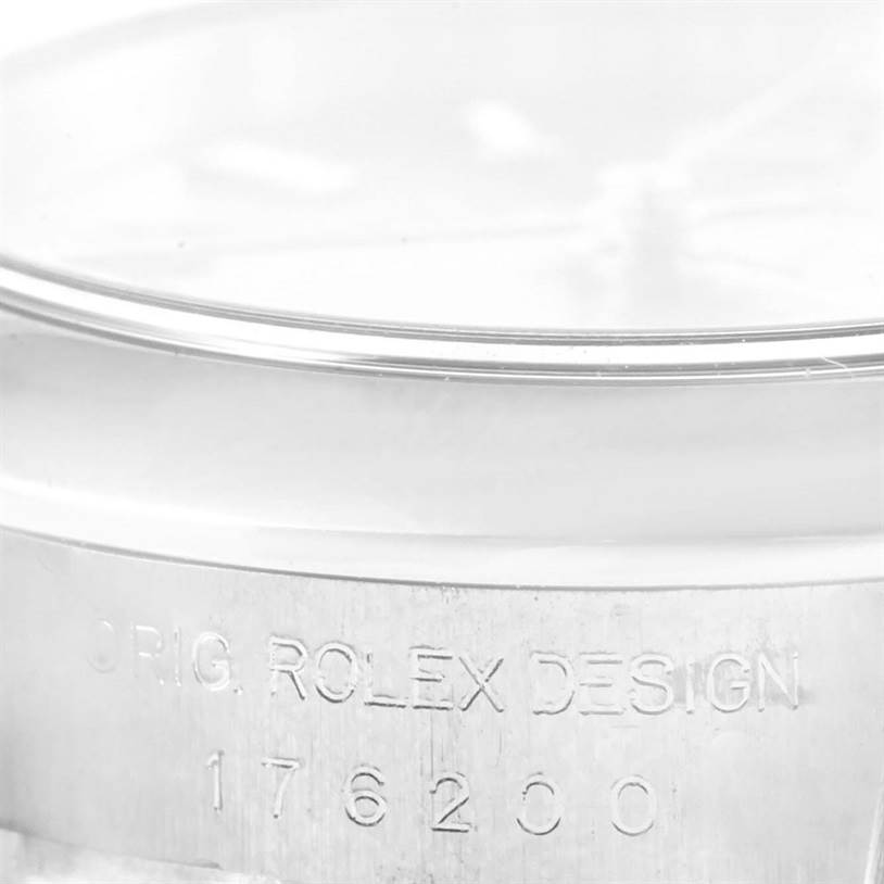 The image shows a close-up of the case and bezel of a Rolex Oyster Perpetual 176200 Women's Stainless Steel Pink Dial 176200 Women's Stainless Steel Pink Dial watch, detailing the engraving.