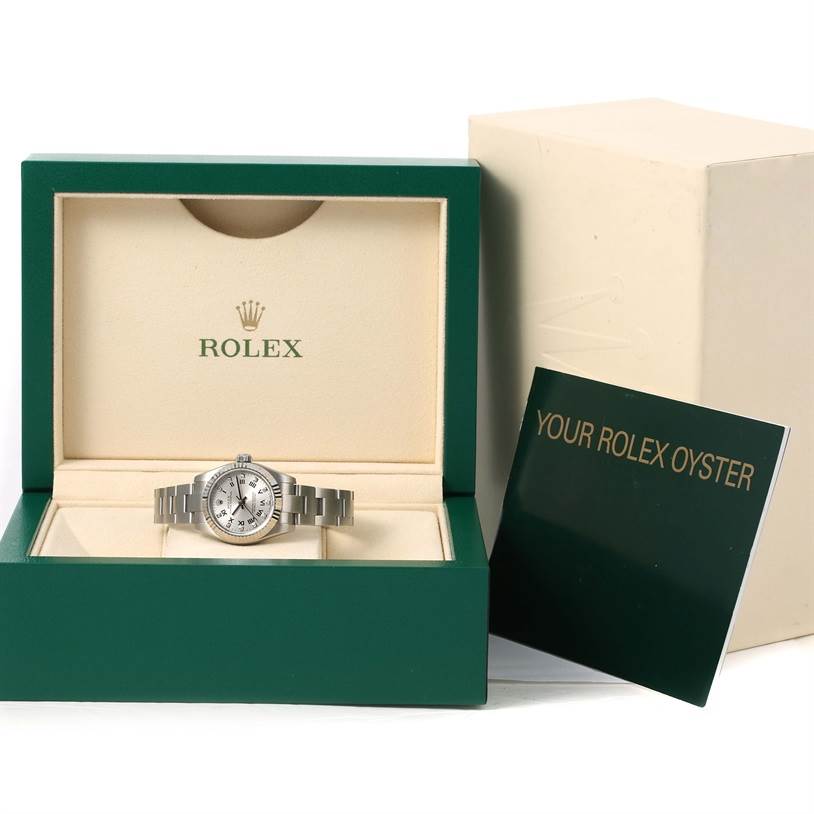 The Rolex Oyster Perpetual 176234 Women's Stainless Steel Grey Dial 176234 Women's Stainless Steel Grey Dial watch is displayed in its open case, with the user manual beside it.