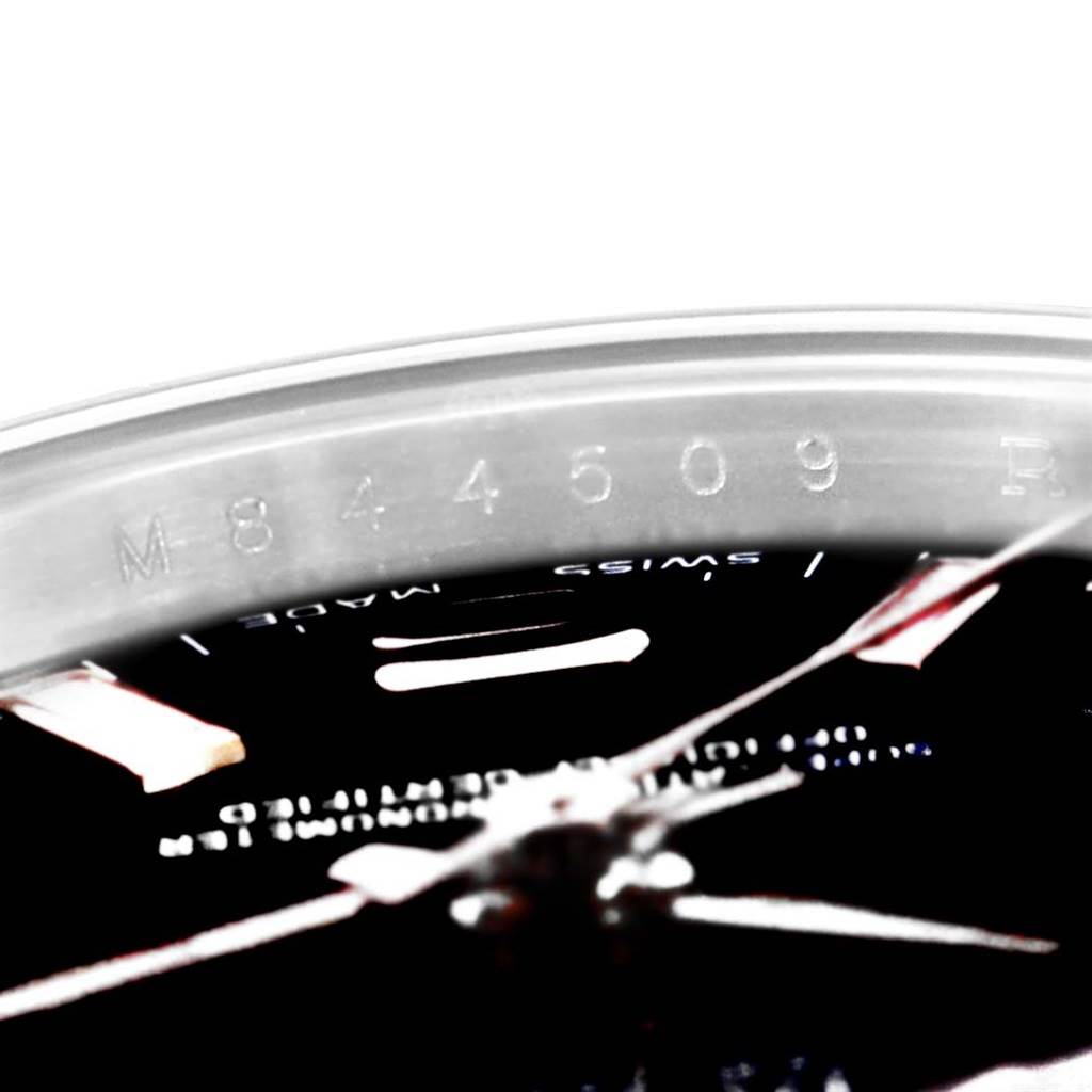 This close-up of a Rolex Oyster Perpetual 176234 Women
s Stainless Steel Black Dial 176234 Women
s Stainless Steel Black Dial watch shows part of the bezel and dial, with visible serial markings.