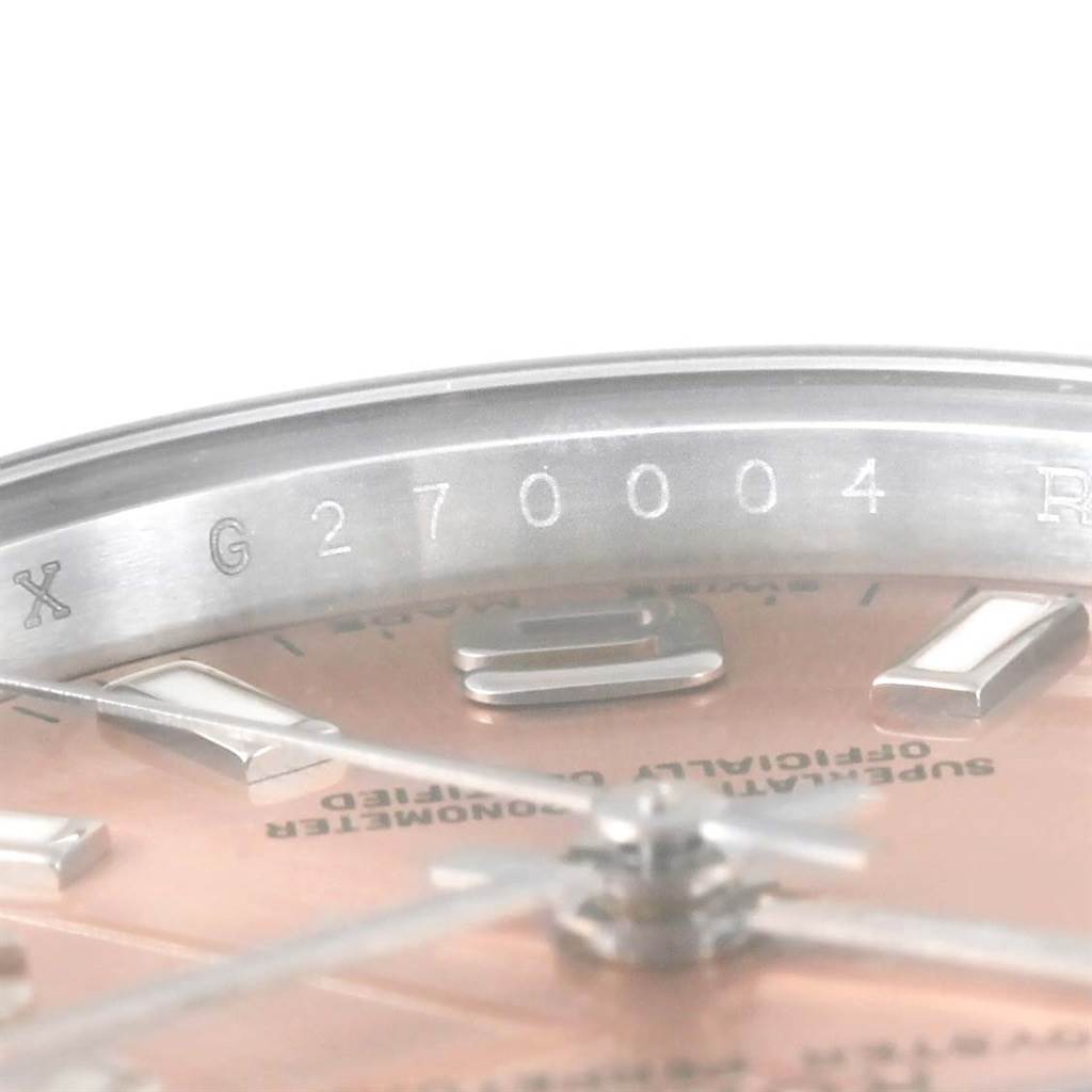 The image shows the serial number engraving on the inner bezel and part of the dial of a Rolex Oyster Perpetual 176200 Women's Stainless Steel Pink Dial 176200 Women's Stainless Steel Pink Dial watch.