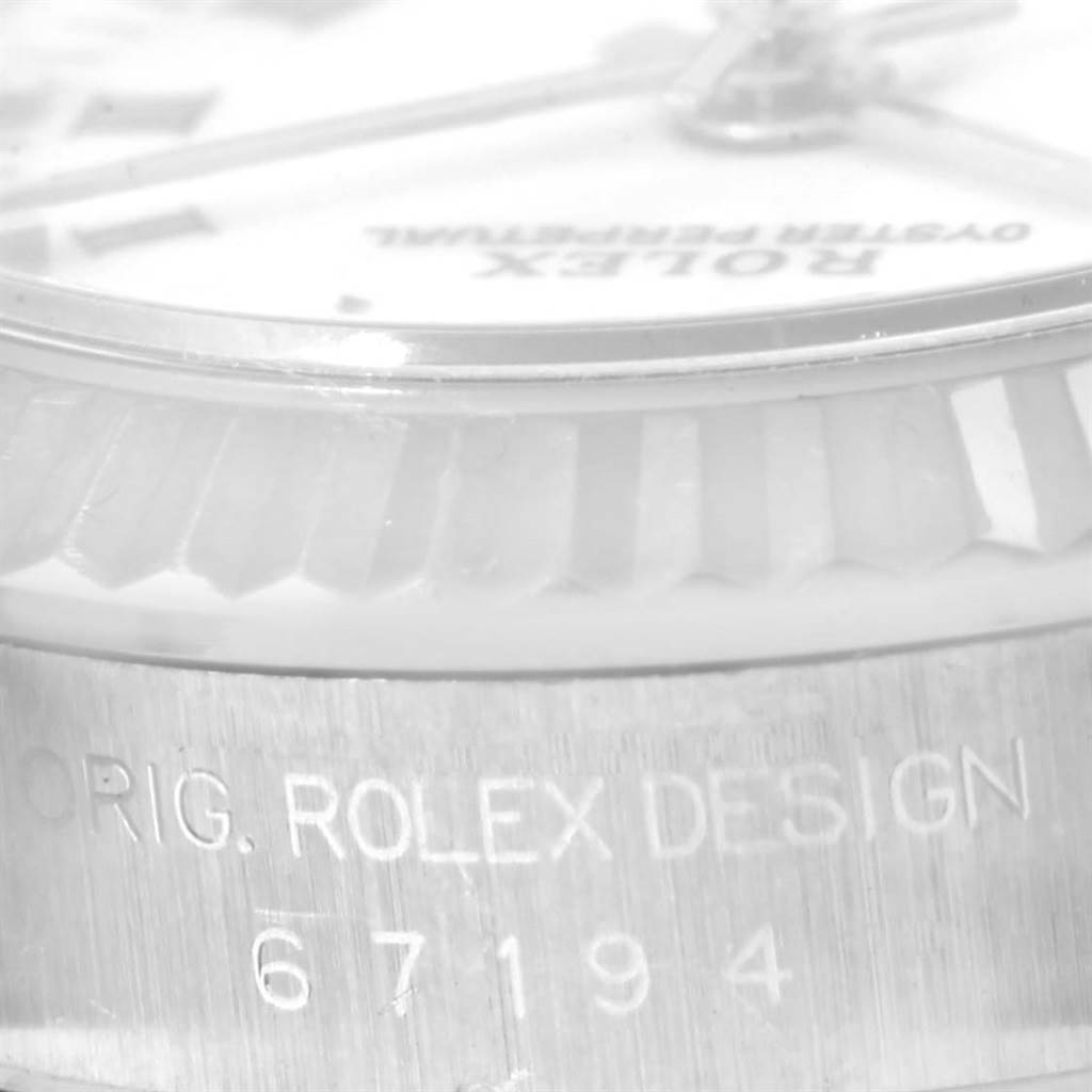 This close-up image shows the side of a Rolex Oyster Perpetual 67194 Women's Stainless Steel White Dial 67194 Women's Stainless Steel White Dial watch, highlighting the model number "67194" and "Orig. Rolex Design" engraving.