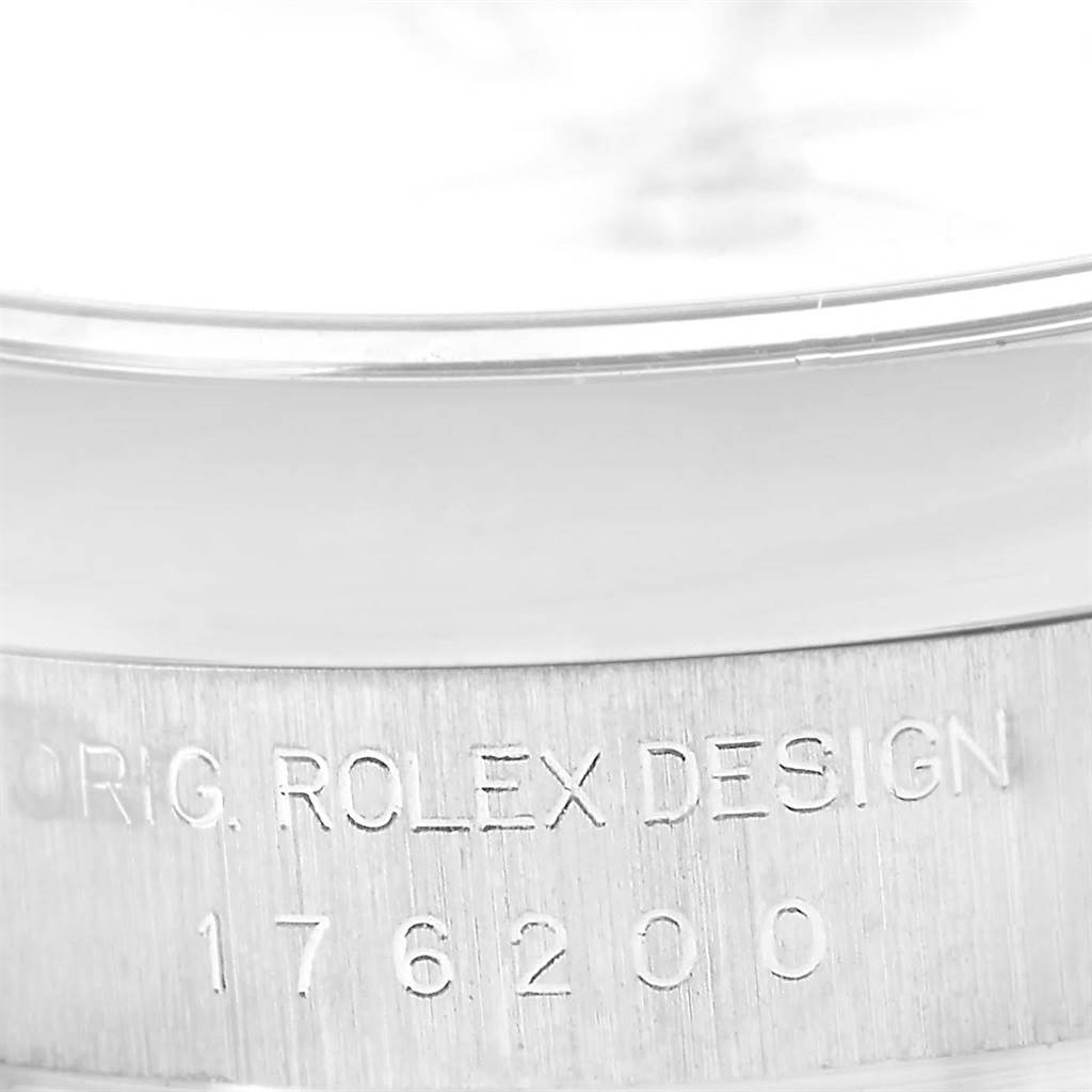 This image shows a close-up of the Rolex Oyster Perpetual 176200 Women
s Stainless Steel White Dial 176200 Women
s Stainless Steel White Dial watch case with the engraving "ORIG. ROLEX DESIGN" and the model number "176200".