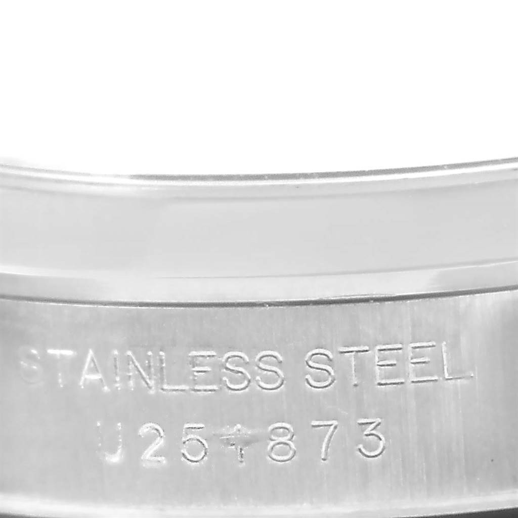 The image shows a close-up of the stainless steel bracelet of a Rolex Oyster Perpetual 67180 Men
s Stainless Steel Blue Dial 67180 Men
s Stainless Steel Blue Dial watch, displaying part of its serial number and material.