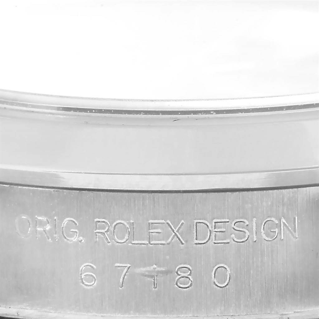 This image shows a close-up of the side, highlighting the serial number and "ORIG. ROLEX DESIGN" engraving on the Rolex Oyster Perpetual 67180 Men
s Stainless Steel Blue Dial 67180 Men
s Stainless Steel Blue Dial watch.