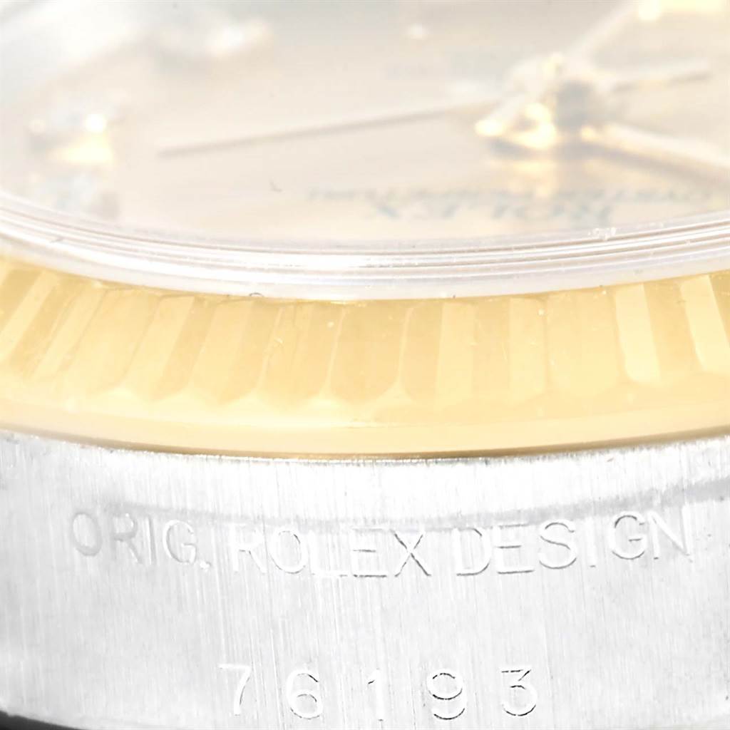 The close-up image of a Rolex Oyster Perpetual 76193 Women's Steel and Gold (two tone) Champagne Dial 76193 Women's Steel and Gold (two tone) Champagne Dial watch shows the case side with the engraving "ORIG. ROLEX DESIGN" and model number 76193.