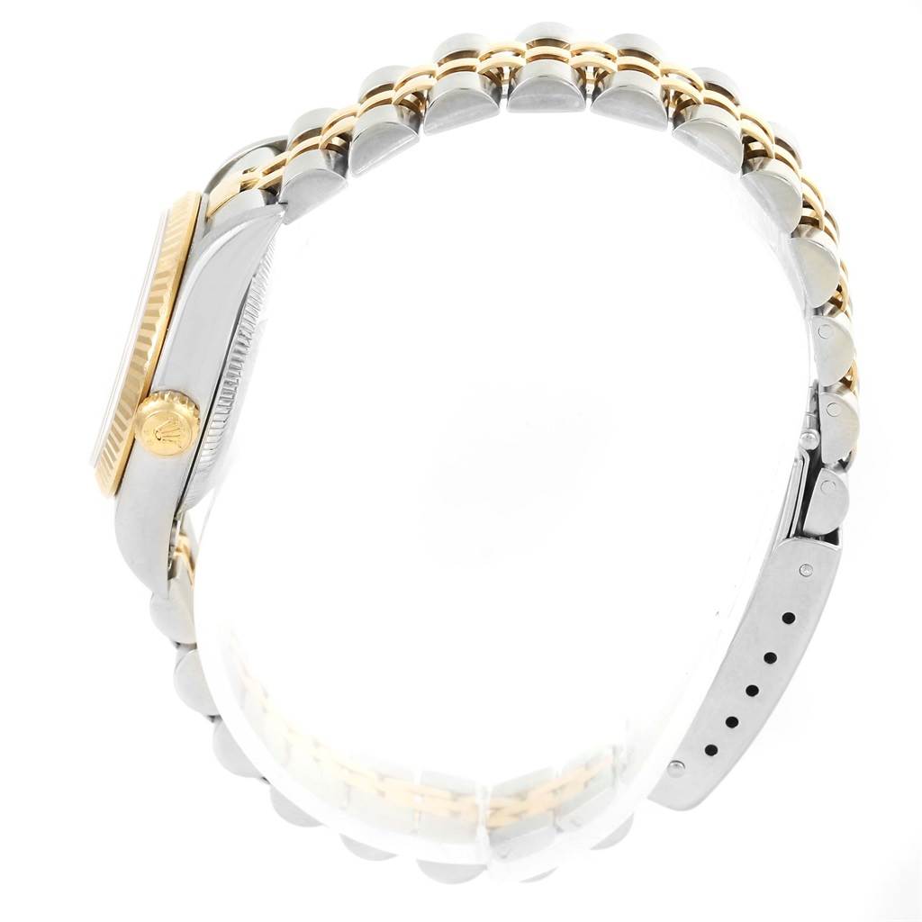 The image shows a side view of the Rolex Oyster Perpetual 76193 Women's Steel and Gold (two tone) Champagne Dial 76193 Women's Steel and Gold (two tone) Champagne Dial watch, highlighting part of the bracelet and the crown logo on the side.