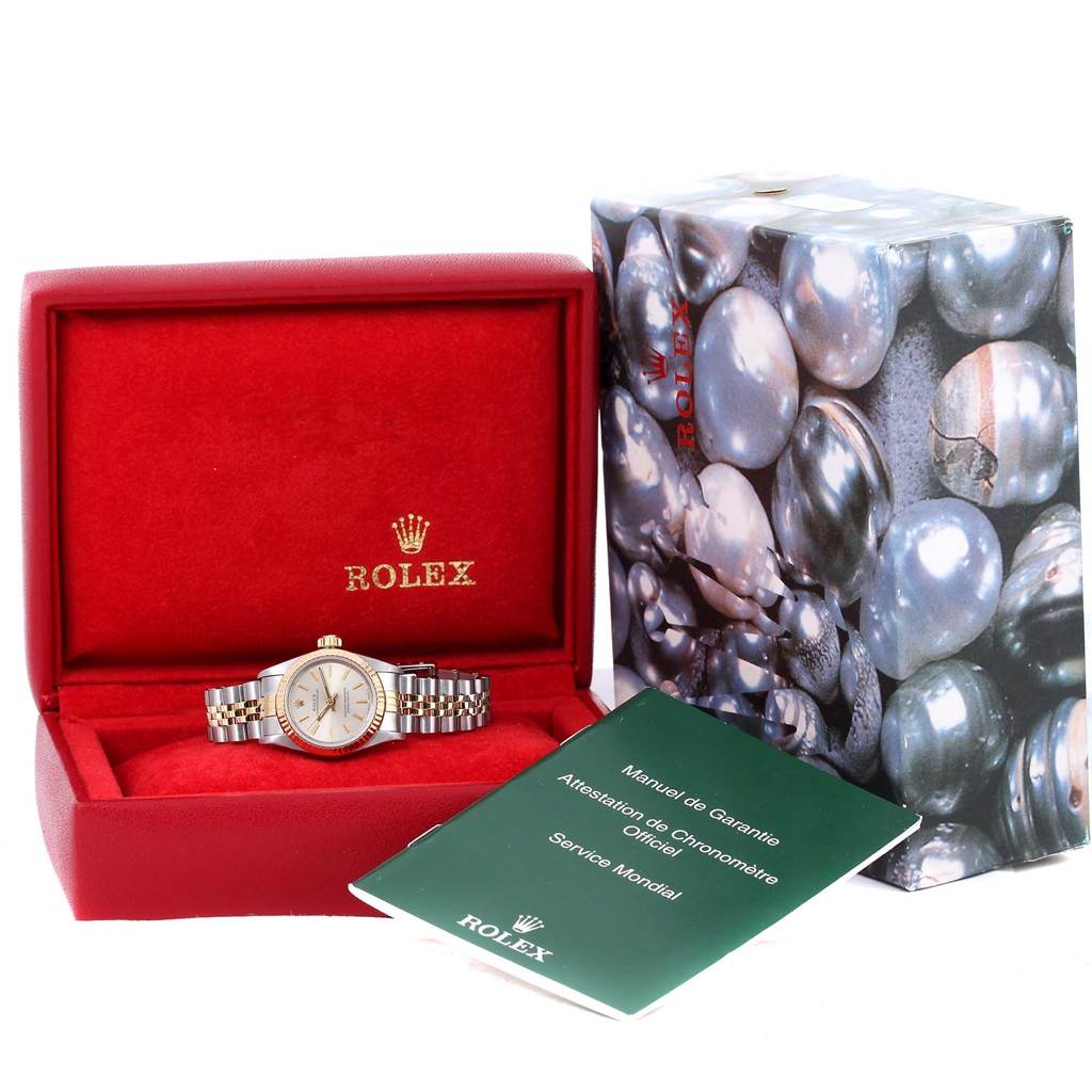 The Rolex Oyster Perpetual 67193 Women's Steel and Gold (two tone) Silver Dial 67193 Women's Steel and Gold (two tone) Silver Dial watch is shown in its case, along with its manual and warranty booklet.