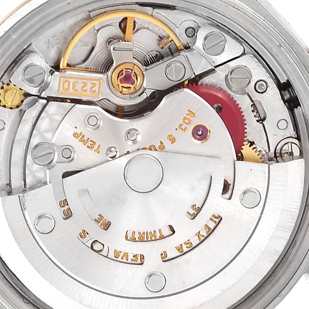 This close-up image shows the internal mechanical movement of the Rolex Oyster Perpetual 76183 Women's Steel and Gold (two tone) Grey Dial 76183 Women's Steel and Gold (two tone) Grey Dial watch, highlighting gears and inscriptions.