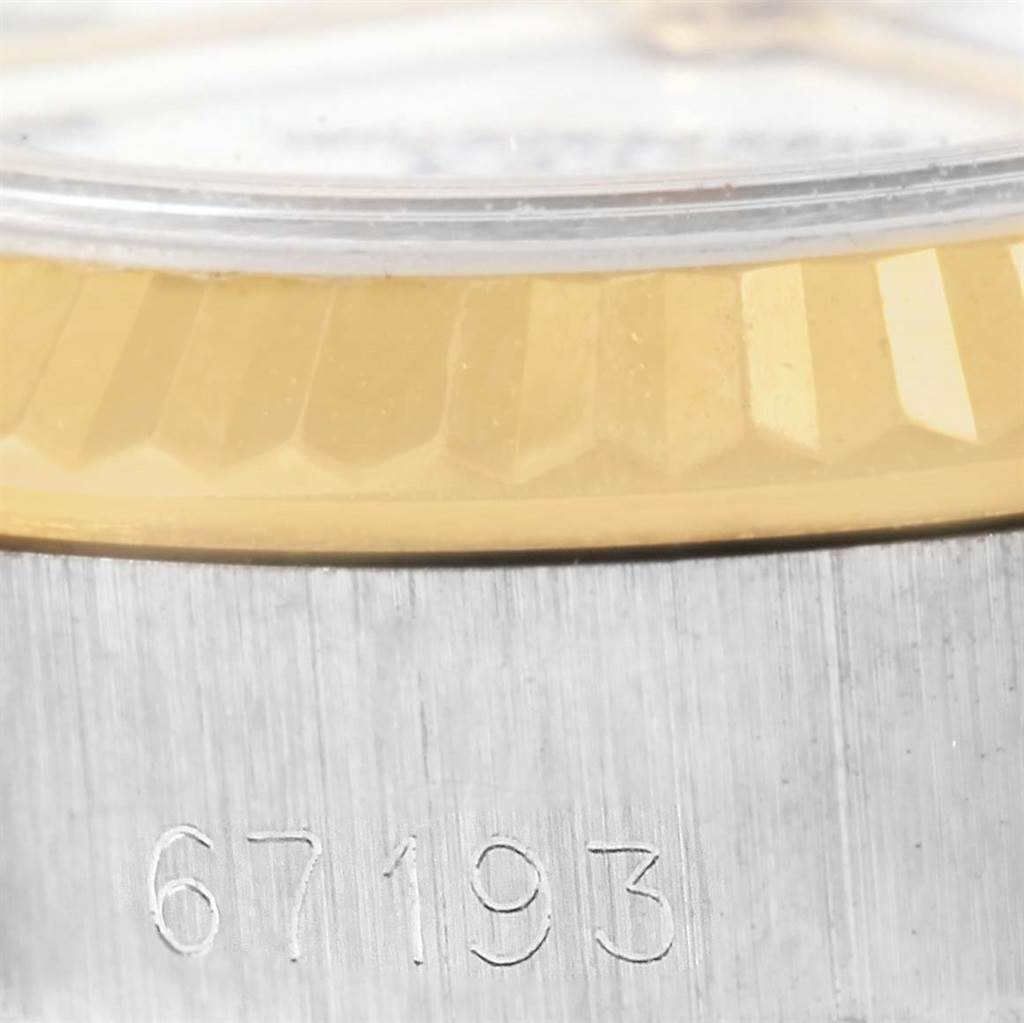 This close-up image of the Rolex Oyster Perpetual 67193 Women's Steel and Gold (two tone) White Dial 67193 Women's Steel and Gold (two tone) White Dial watch shows the side view, focusing on the bezel and engraved model number.