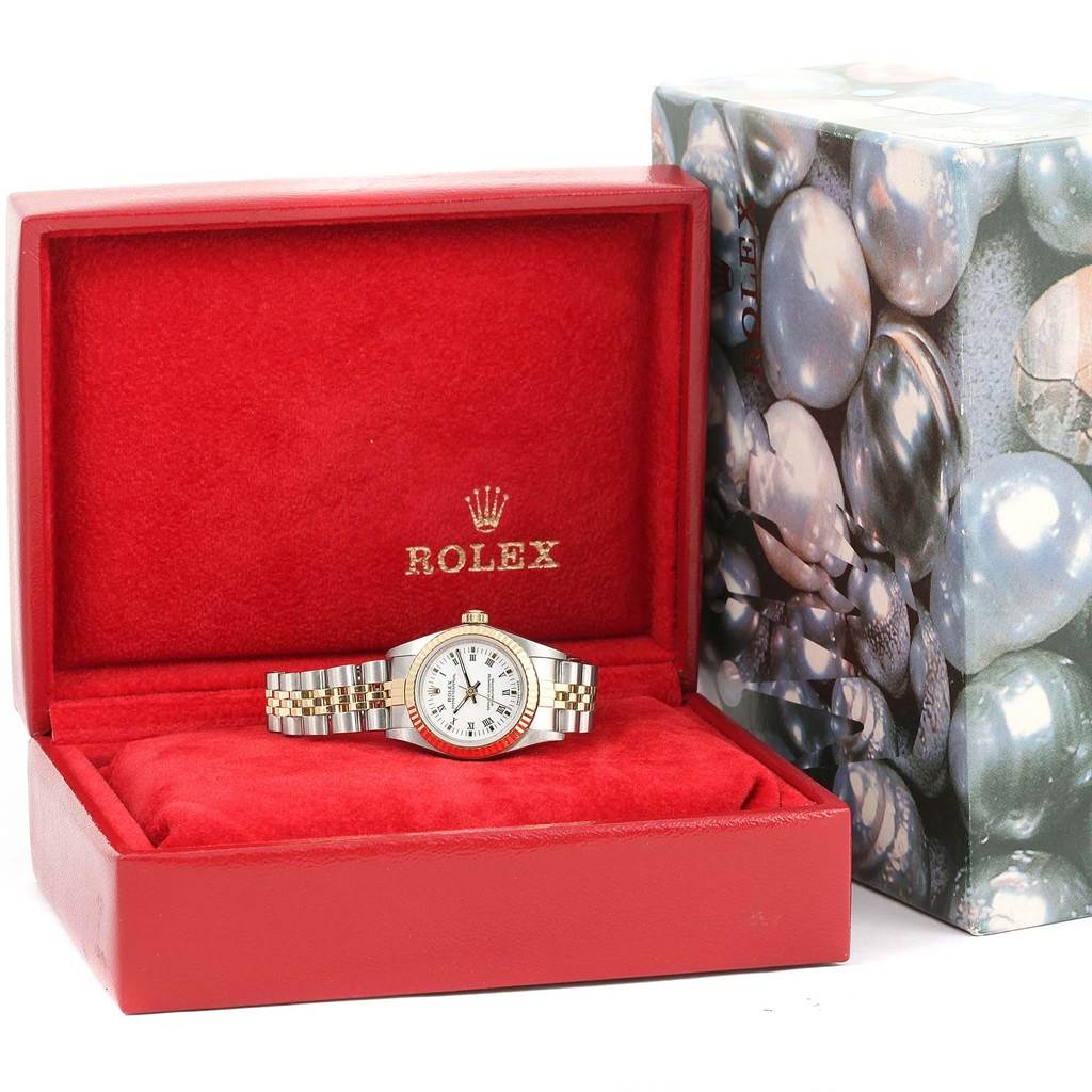 The Rolex Oyster Perpetual 76193 Women's Steel and Gold (two tone) White Dial 76193 Women's Steel and Gold (two tone) White Dial watch is shown from the front, displayed in an open red box with its original packaging beside it.
