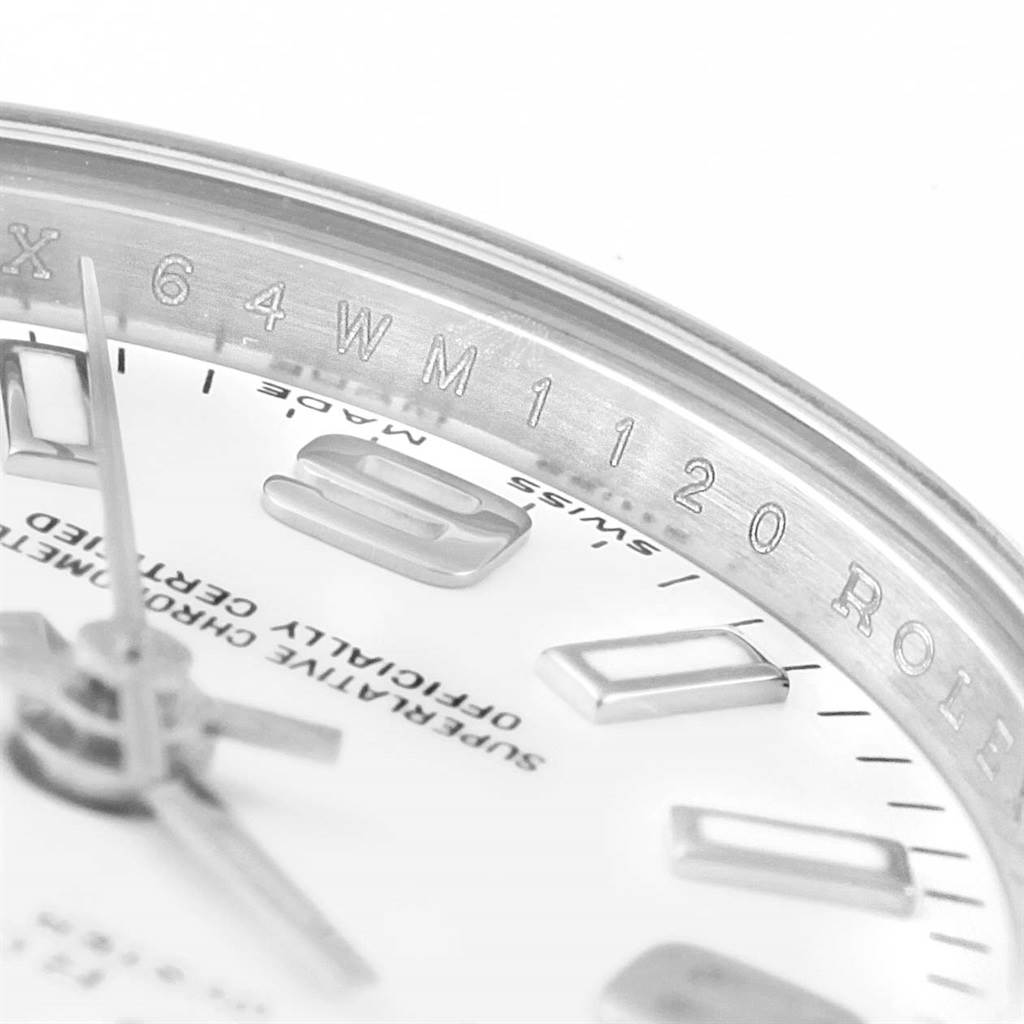 This close-up angle of the Rolex Oyster Perpetual 176200 Women's Stainless Steel White Dial 176200 Women's Stainless Steel White Dial watch shows the dial, markers, hands, and inner bezel with engravings.