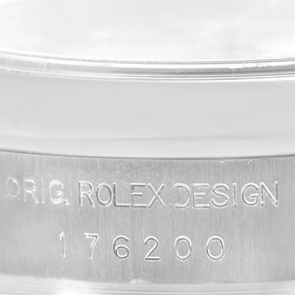 This close-up image shows the engraved serial number and design marking on the case of a Rolex Oyster Perpetual 176200 Women
s Stainless Steel Silver Dial 176200 Women
s Stainless Steel Silver Dial watch.