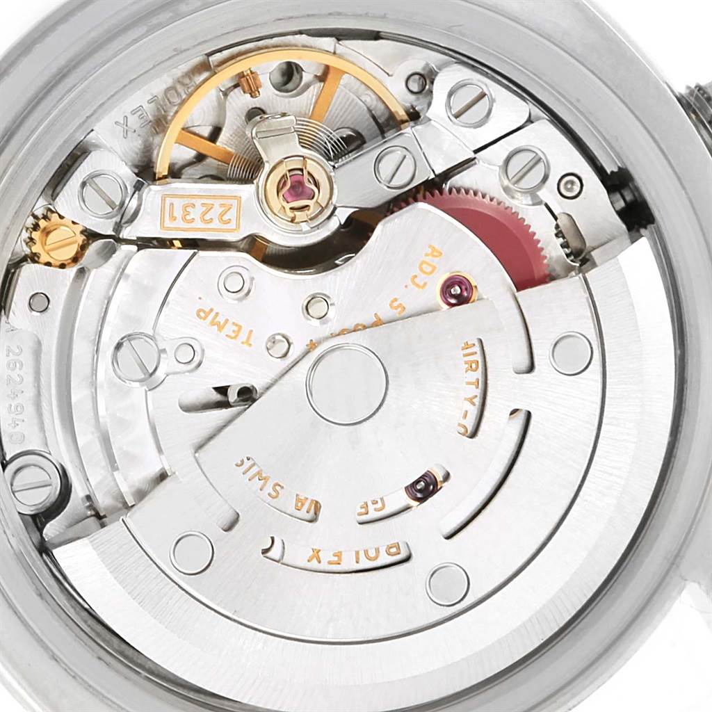 The image shows the intricate internal mechanics of a Rolex Oyster Perpetual 176200 Women
s Stainless Steel Silver Dial 176200 Women
s Stainless Steel Silver Dial watch from the back, revealing the movement and gears.