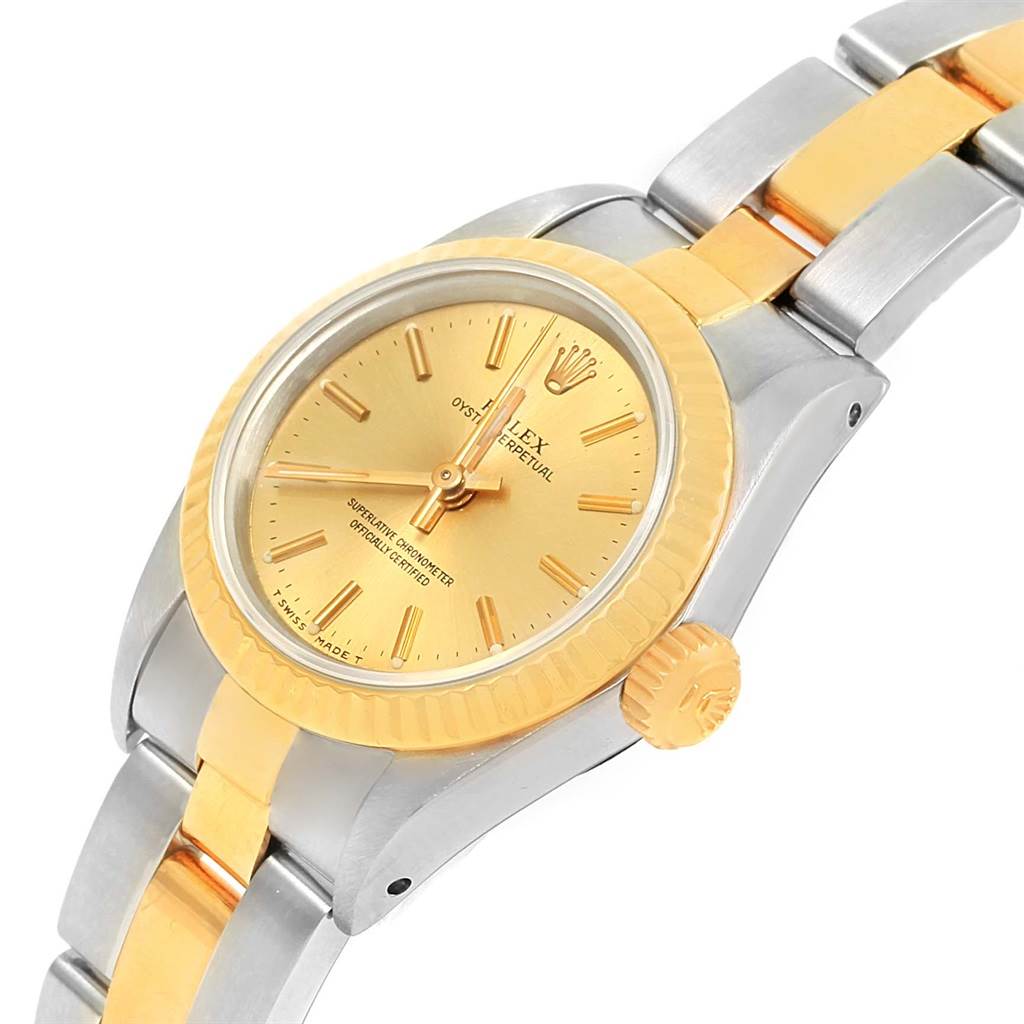 This image shows a detailed angled side view of a Rolex Oyster Perpetual 67193 Women's Steel and Gold (two tone) Champagne Dial 67193 Women's Steel and Gold (two tone) Champagne Dial watch, highlighting its gold dial, bezel, and two-tone bracelet.