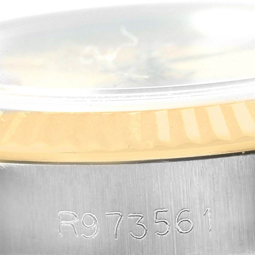 This image shows a close-up view of the serial number and part of the case and bezel of a Rolex Oyster Perpetual 67193 Women's Steel and Gold (two tone) Champagne Dial 67193 Women's Steel and Gold (two tone) Champagne Dial watch.