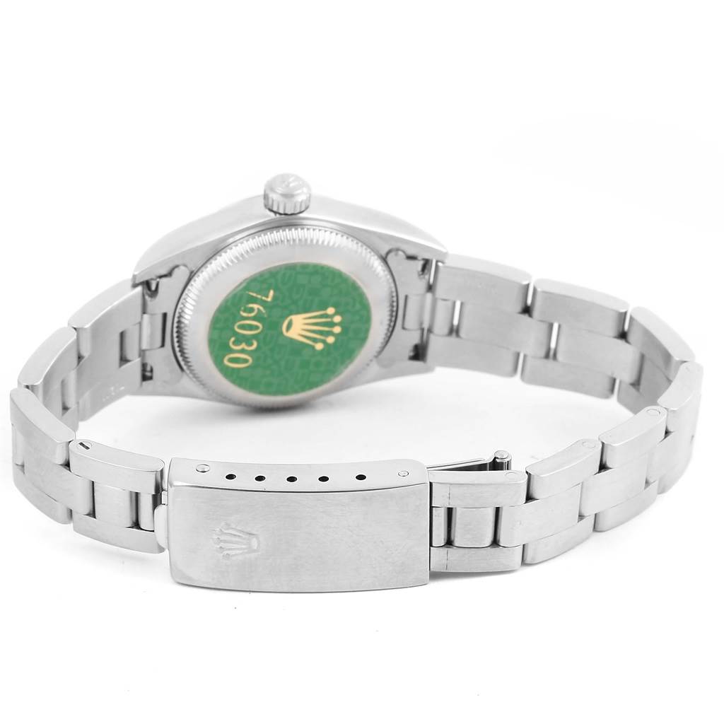 The image shows the back of an Oyster Perpetual Rolex watch and a portion of its bracelet and clasp.
