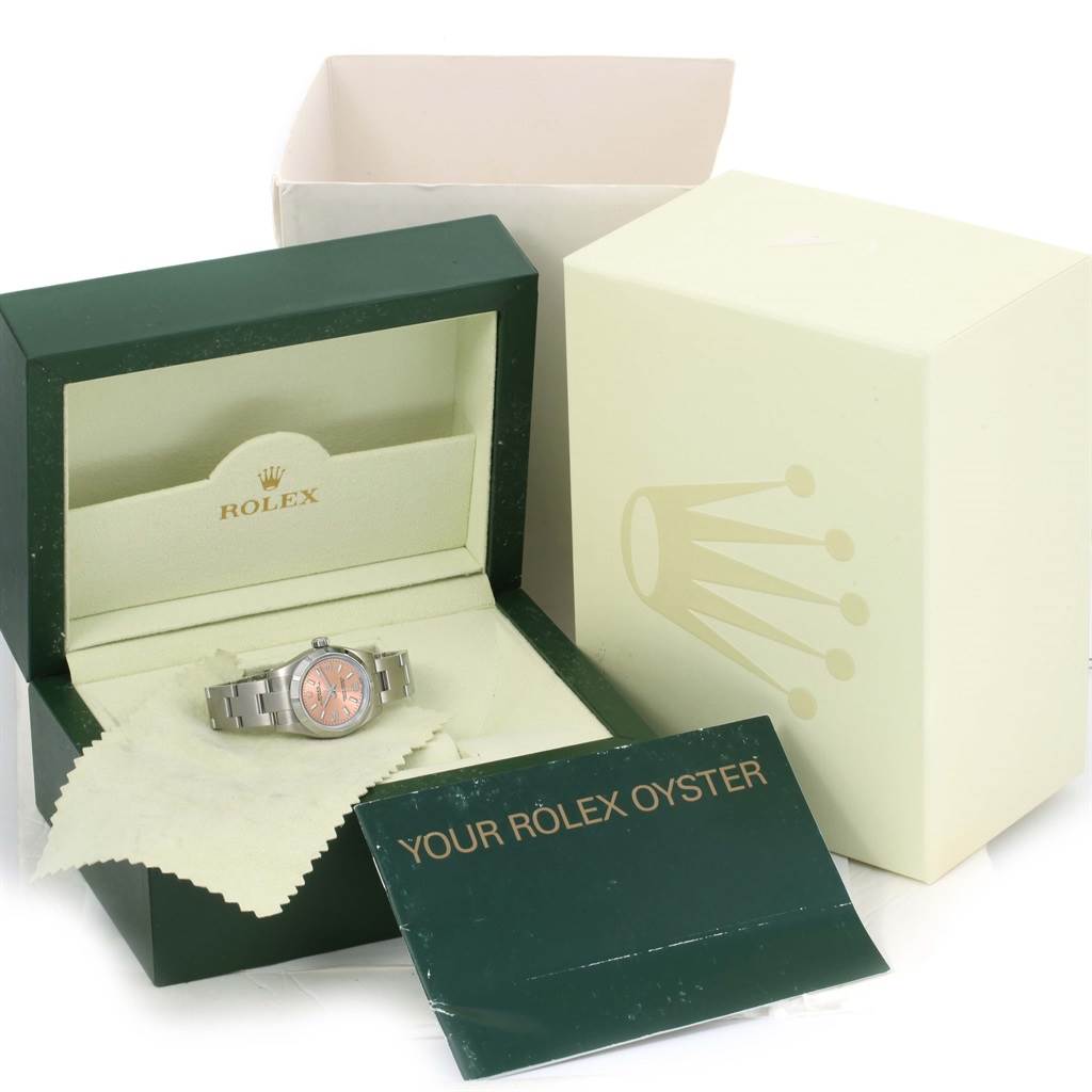 The Rolex Oyster Perpetual 176210 Women's Stainless Steel Pink Dial 176210 Women's Stainless Steel Pink Dial watch is shown at an angle inside its open green and cream-colored box, with accompanying accessories.