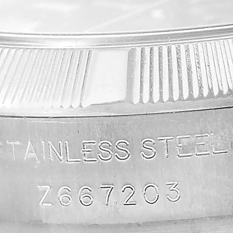 The image shows a close-up of the side of a Rolex Oyster Perpetual 176210 Women's Stainless Steel Pink Dial 176210 Women's Stainless Steel Pink Dial watch, highlighting the fluted bezel and stainless steel engraving.