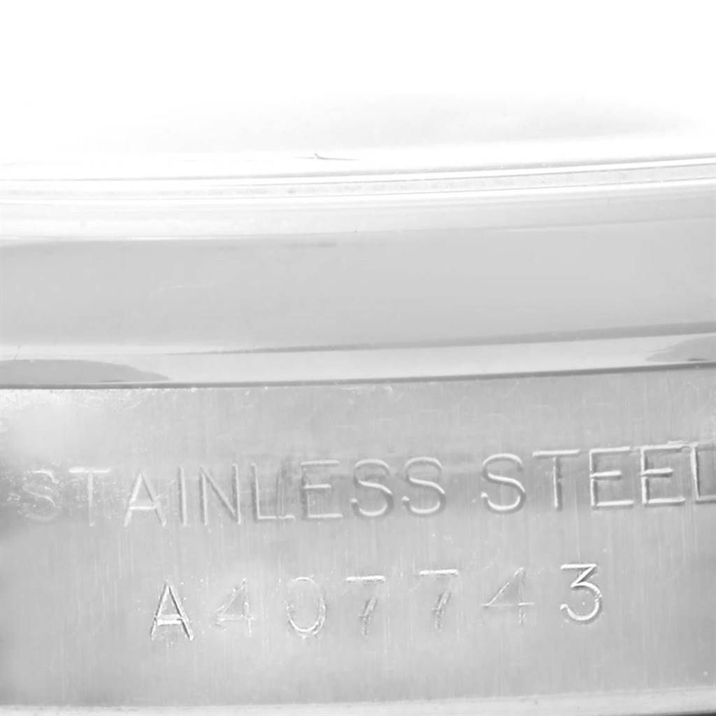 This image shows a close-up of the case side of a Rolex Oyster Perpetual 76080 Women's Stainless Steel Black Dial 76080 Women's Stainless Steel Black Dial watch, featuring the engraving "STAINLESS STEEL A407743".