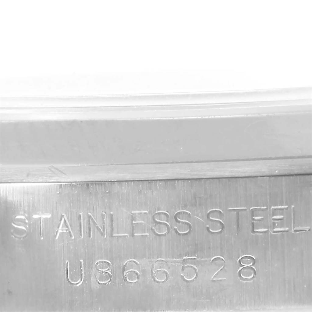 The image shows the side view of a Rolex Oyster Perpetual 67180 Women
s Stainless Steel Pink Dial 67180 Women
s Stainless Steel Pink Dial watch
s stainless steel case with engraved serial numbers.