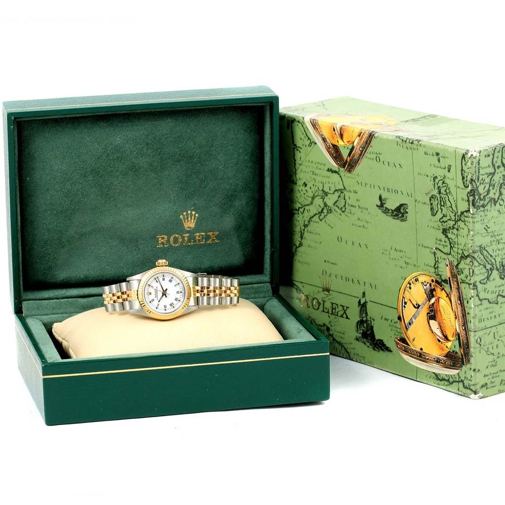 The image shows a Rolex Oyster Perpetual 67193 Women's Steel and Gold (two tone) White Dial 67193 Women's Steel and Gold (two tone) White Dial watch in a green Rolex box with a cream-colored cushion, next to its outer packaging.