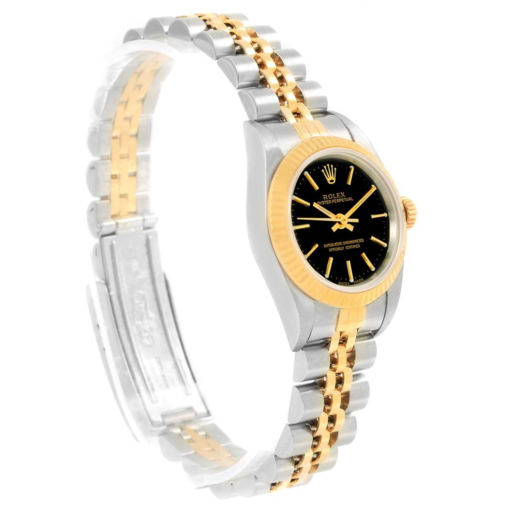 This image shows a Rolex Oyster Perpetual 76193 Women's Steel and Gold (two tone) Black Dial 76193 Women's Steel and Gold (two tone) Black Dial watch at a side angle, highlighting its black dial, date feature, and two-tone bracelet.
