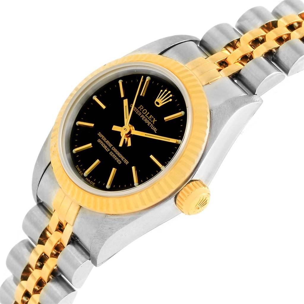 This image shows a side view of the Rolex Oyster Perpetual 76193 Women's Steel and Gold (two tone) Black Dial 76193 Women's Steel and Gold (two tone) Black Dial watch displaying its black dial, gold bezel, gold and silver jubilee bracelet, and crown.