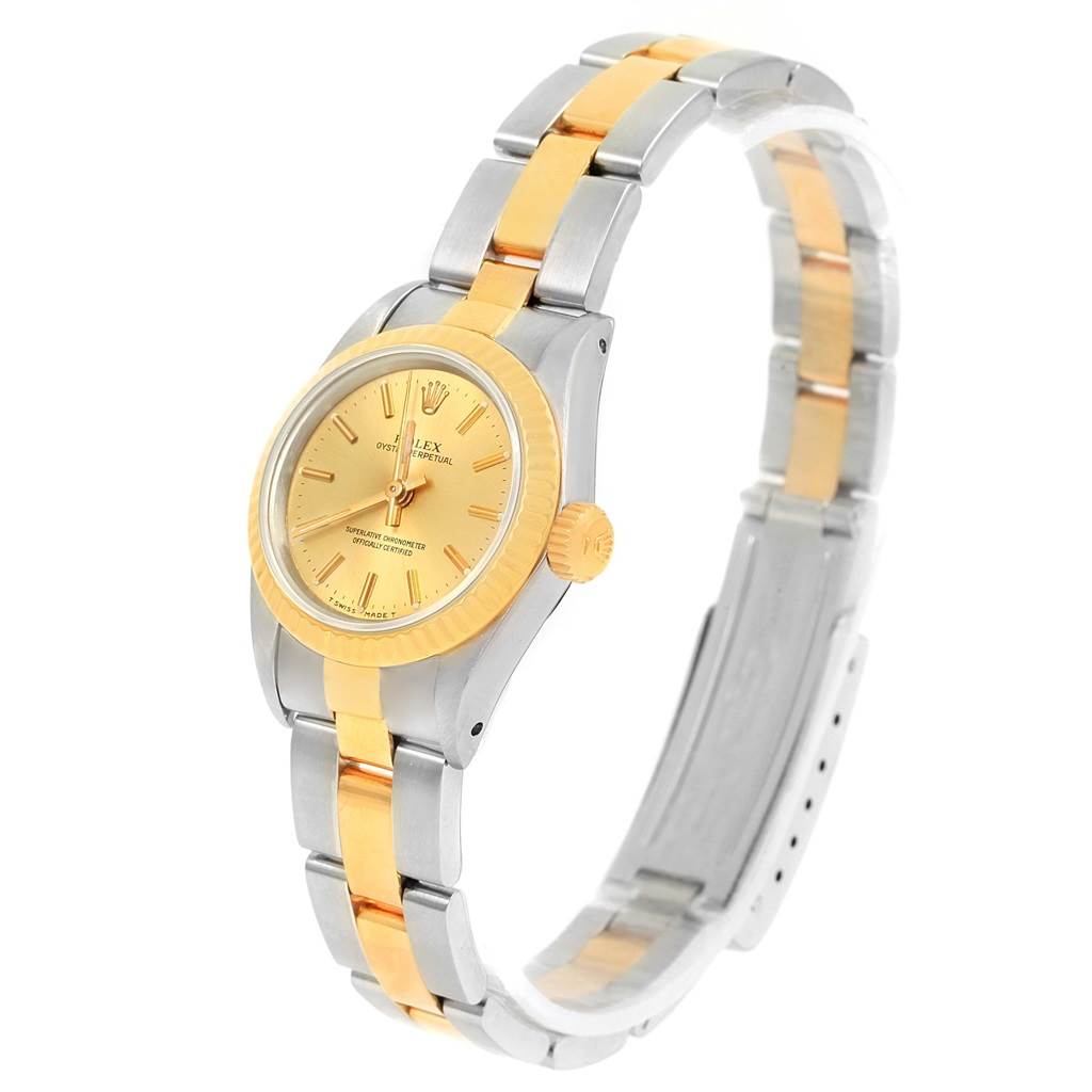 The image shows a Rolex Oyster Perpetual 67193 Women
s Steel and Gold (two tone) Champagne Dial 67193 Women
s Steel and Gold (two tone) Champagne Dial watch at a three-quarter angle, highlighting its gold dial and two-tone metal bracelet.