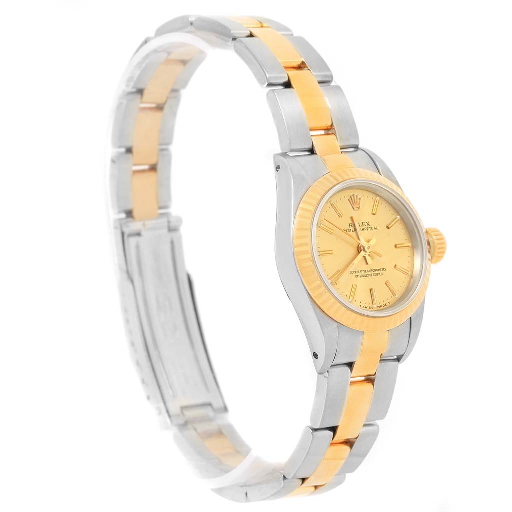The image shows a side angle view of a Rolex Oyster Perpetual 67193 Women
s Steel and Gold (two tone) Champagne Dial 67193 Women
s Steel and Gold (two tone) Champagne Dial watch, highlighting its two-tone metal bracelet and the face of the watch.