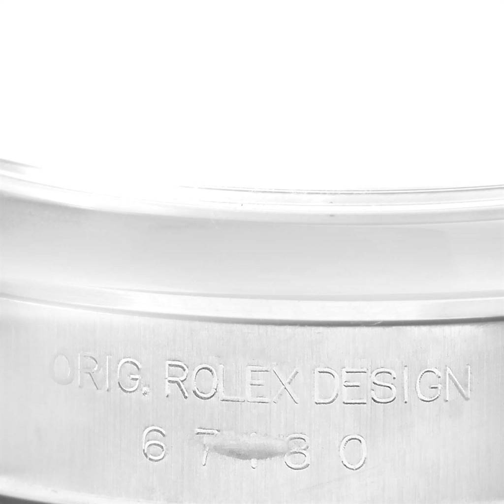 This image shows a close-up of the engraved inner bezel of a Rolex Oyster Perpetual 67180 Women's Stainless Steel Black Dial 67180 Women's Stainless Steel Black Dial watch.