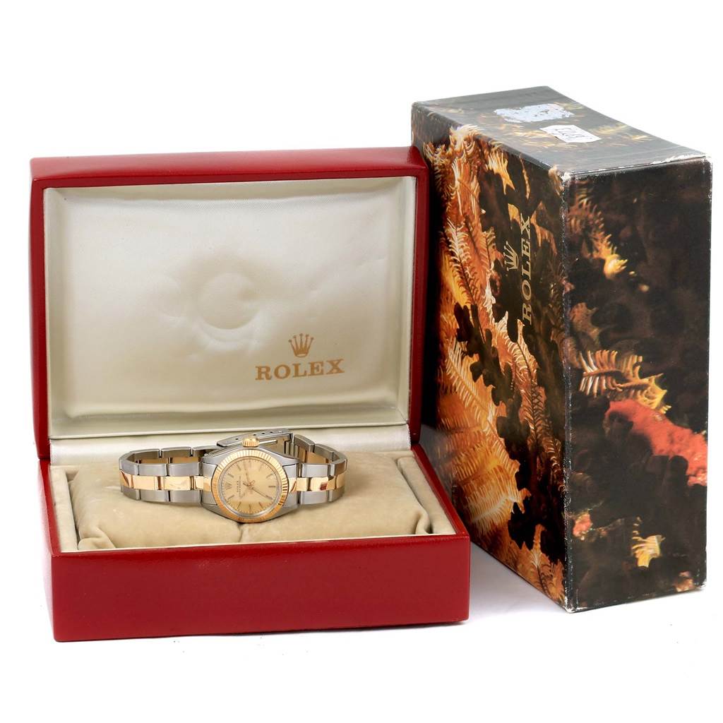 The image shows a Rolex Oyster Perpetual 6719 Women's Steel and Gold (two tone) Champagne Dial 6719 Women's Steel and Gold (two tone) Champagne Dial watch inside its red case with a decorative outer box beside it.
