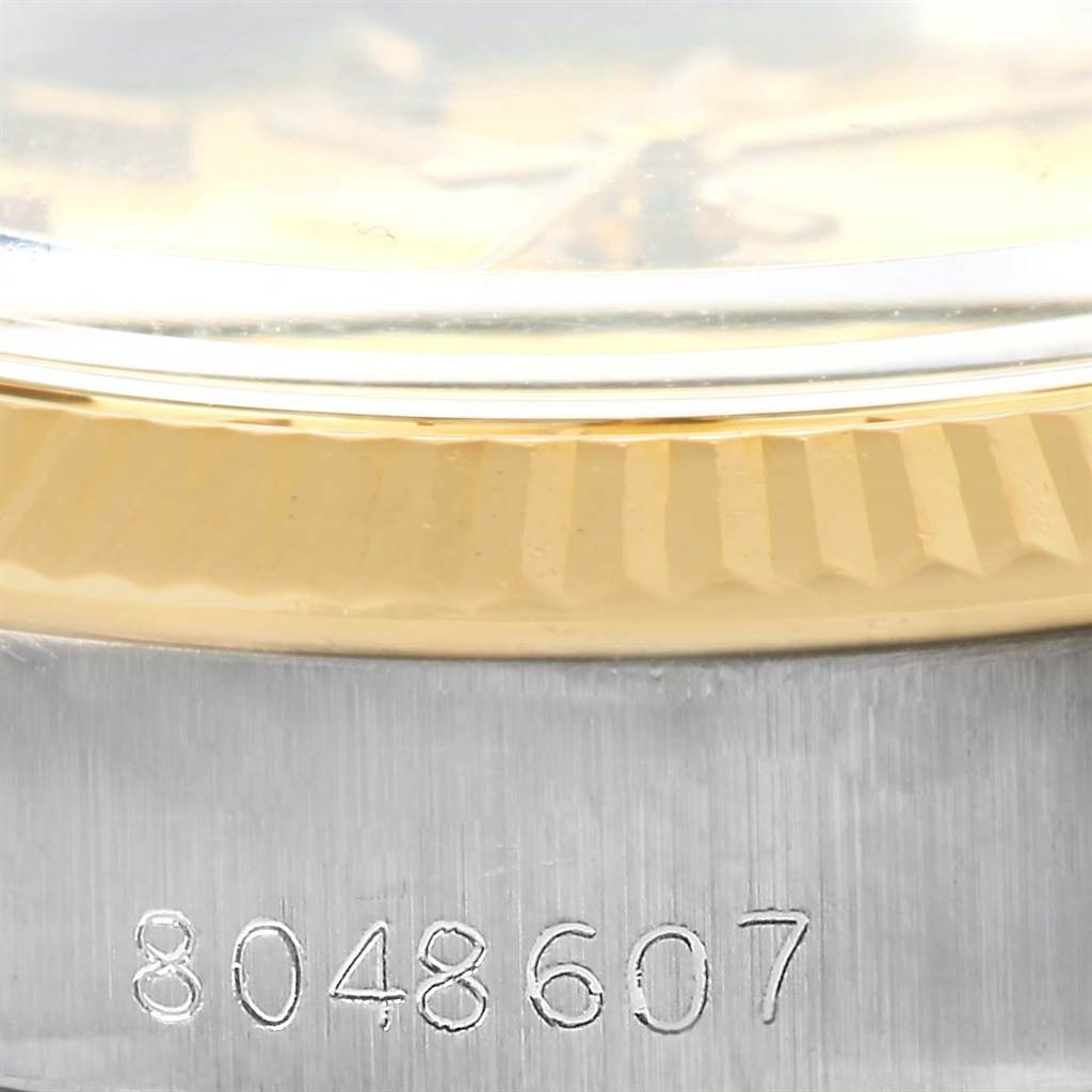 This image shows a close-up of the serial number and a portion of the bezel on a Rolex Oyster Perpetual 6719 Women's Steel and Gold (two tone) Champagne Dial 6719 Women's Steel and Gold (two tone) Champagne Dial watch.