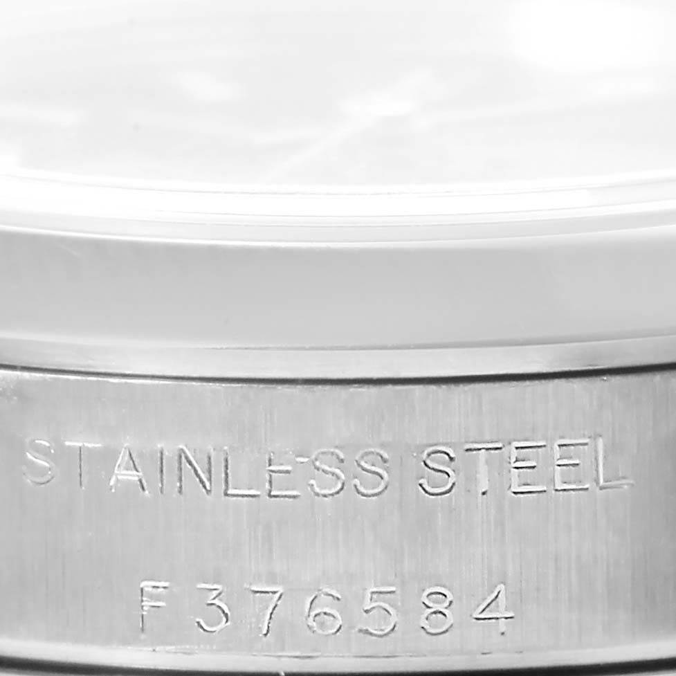 This is a close-up of the side of a Rolex Oyster Perpetual 76080 Women
s Stainless Steel Black Dial 76080 Women
s Stainless Steel Black Dial watch, showing the "STAINLESS STEEL" and serial number engraving.