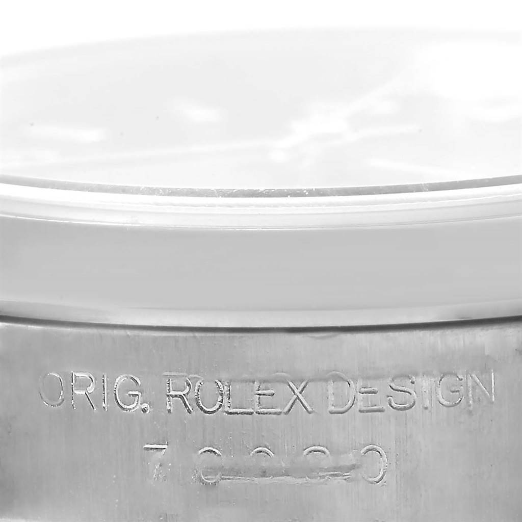 This image shows a close-up of the side of the Rolex Oyster Perpetual 76080 Women
s Stainless Steel Blue Dial 76080 Women
s Stainless Steel Blue Dial watch case, highlighting the engraved "ORIG. ROLEX DESIGN" text.