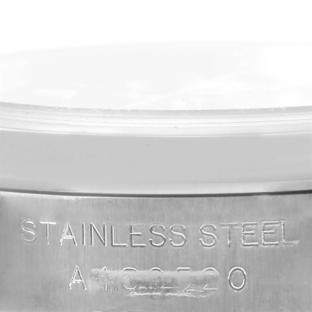 This image shows a close-up angle of the casing of a Rolex Oyster Perpetual 76080 Women
s Stainless Steel Blue Dial 76080 Women
s Stainless Steel Blue Dial watch, highlighting the "Stainless Steel" engraving.