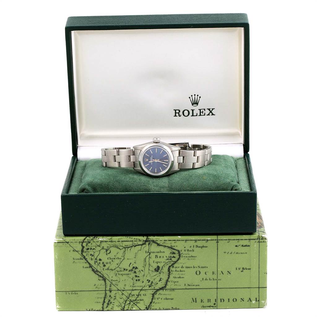The Rolex Oyster Perpetual 67180 Women
s Stainless Steel Blue Dial 67180 Women
s Stainless Steel Blue Dial watch is displayed in its open box, showing the face, bracelet, and cushion.
