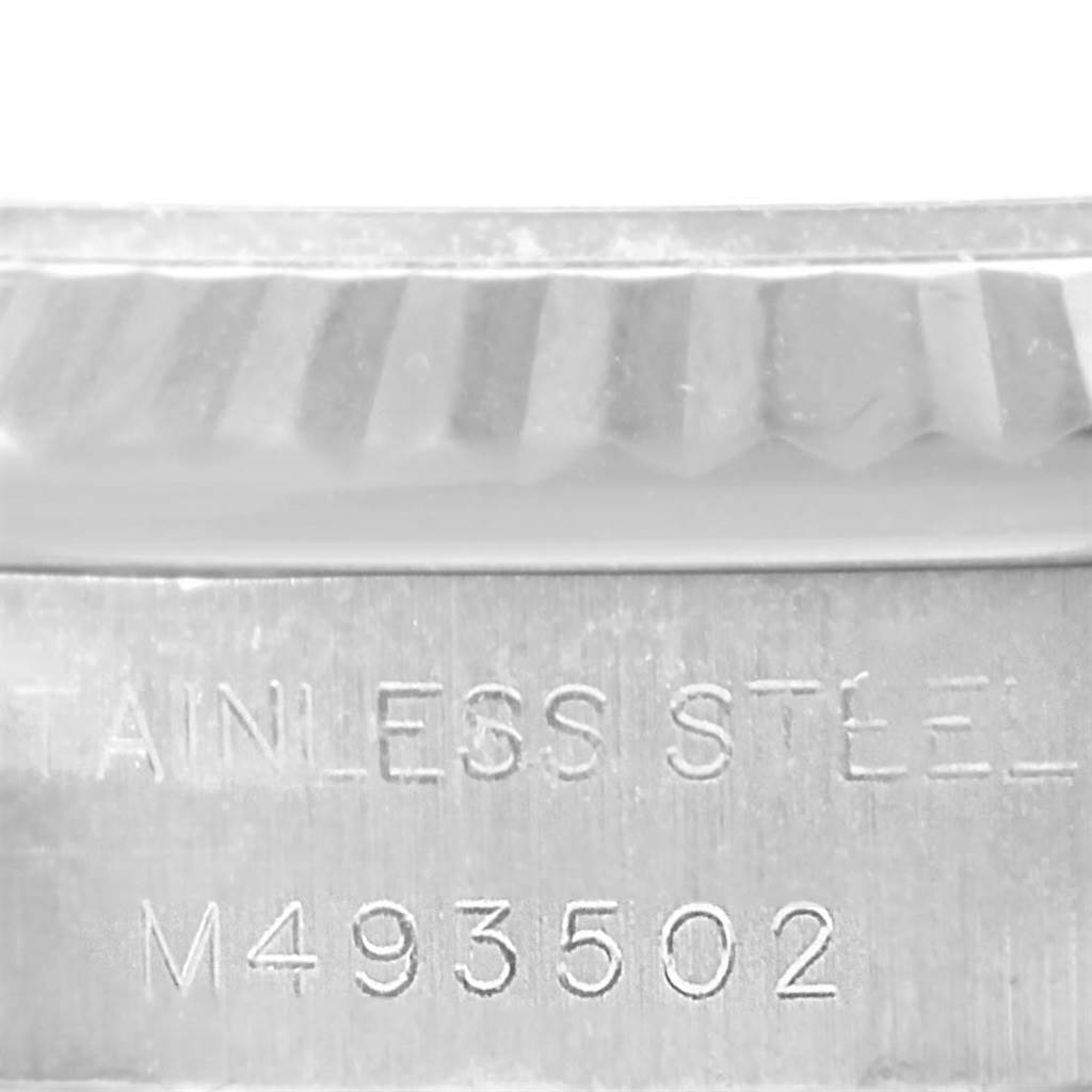 This image shows a close-up of the side of the case back and edge of the bezel of a Rolex Oyster Perpetual 176234 Women
s Stainless Steel Pink Dial 176234 Women
s Stainless Steel Pink Dial watch, highlighting the serial number and "STAINLESS STEEL" engraving.