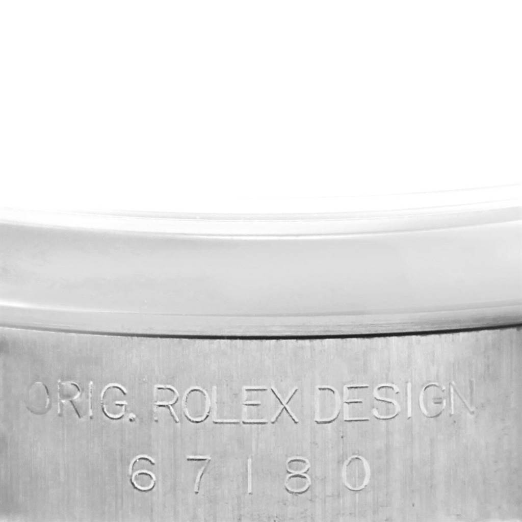 The image shows a close-up of the case side of a Rolex Oyster Perpetual 67180 Women
s Stainless Steel Silver Dial 67180 Women
s Stainless Steel Silver Dial watch, revealing the engraved model number "67180."