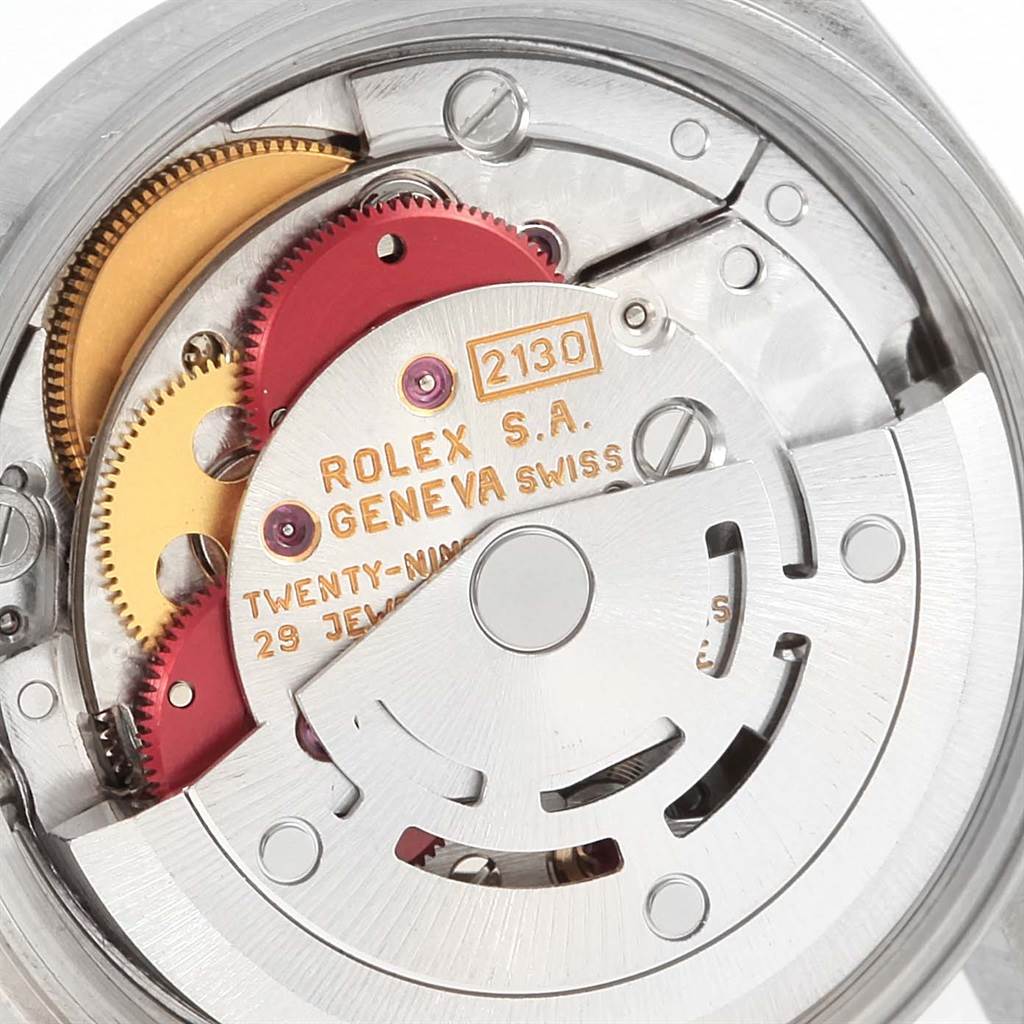 This is a close-up view of the movement components of a Rolex Oyster Perpetual 67180 Women
s Stainless Steel Silver Dial 67180 Women
s Stainless Steel Silver Dial model, showcasing gears and inscriptions.