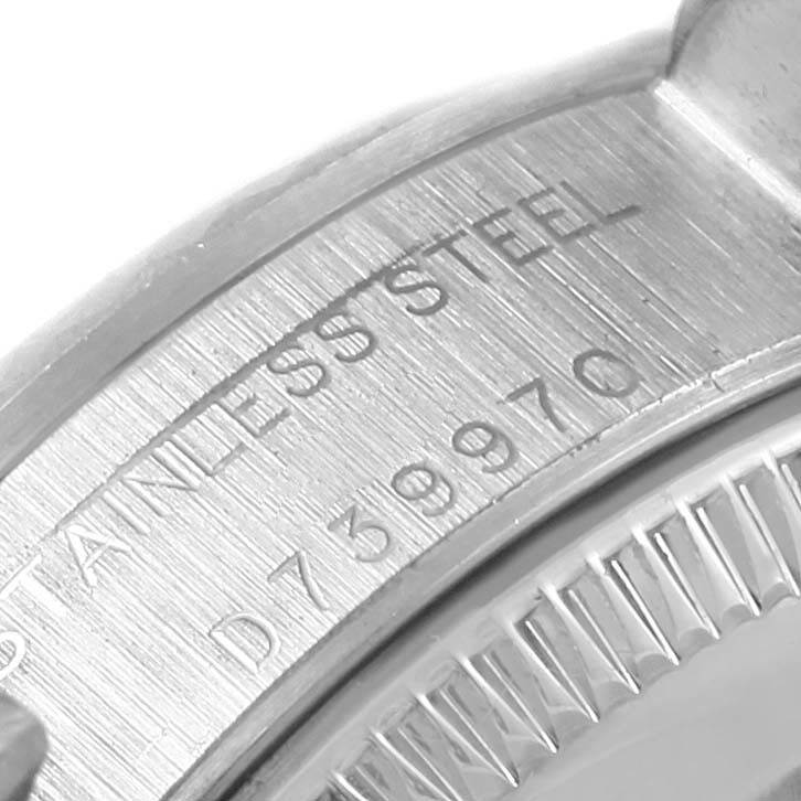 This image shows a close-up of the back case of a Rolex Oyster Perpetual 76094 Women
s Stainless Steel Pink Dial 76094 Women
s Stainless Steel Pink Dial watch, highlighting the serial number and "STAINLESS STEEL" engraving.