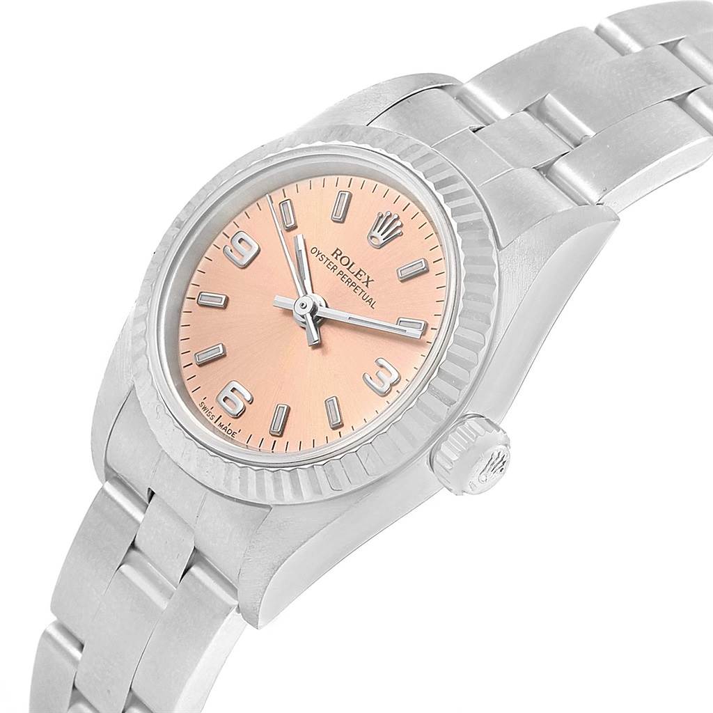 The image shows a Rolex Oyster Perpetual 76094 Women
s Stainless Steel Pink Dial 76094 Women
s Stainless Steel Pink Dial watch angled to display its dial, bezel, crown, and part of its bracelet.