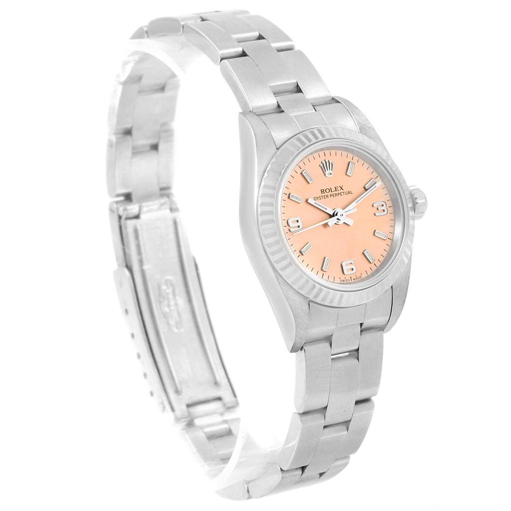 The image shows a Rolex Oyster Perpetual 76094 Women
s Stainless Steel Pink Dial 76094 Women
s Stainless Steel Pink Dial watch at a slightly tilted angle, highlighting its peach-colored dial and stainless steel bracelet.