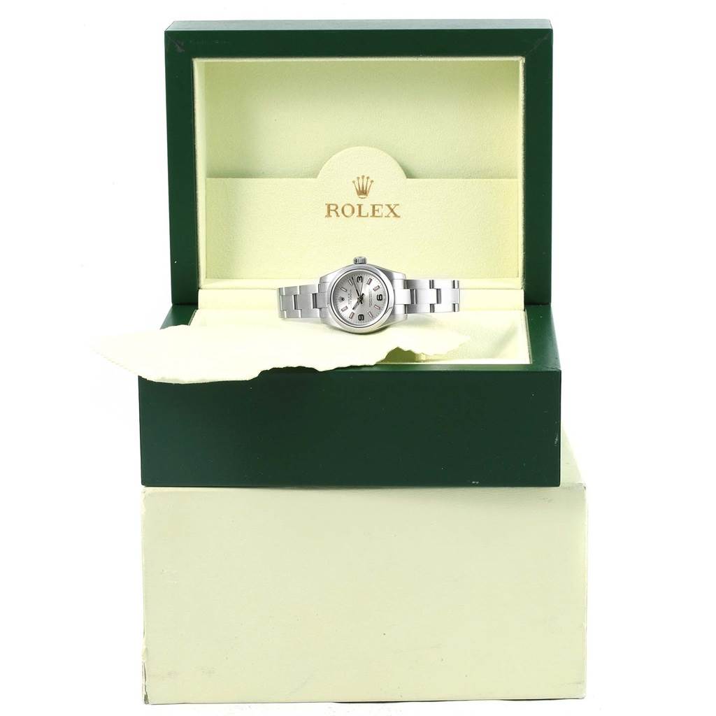 The Rolex Oyster Perpetual 176200 Women
s Stainless Steel Silver Dial 176200 Women
s Stainless Steel Silver Dial watch is shown inside an open green and cream presentation box at a straight-on angle.