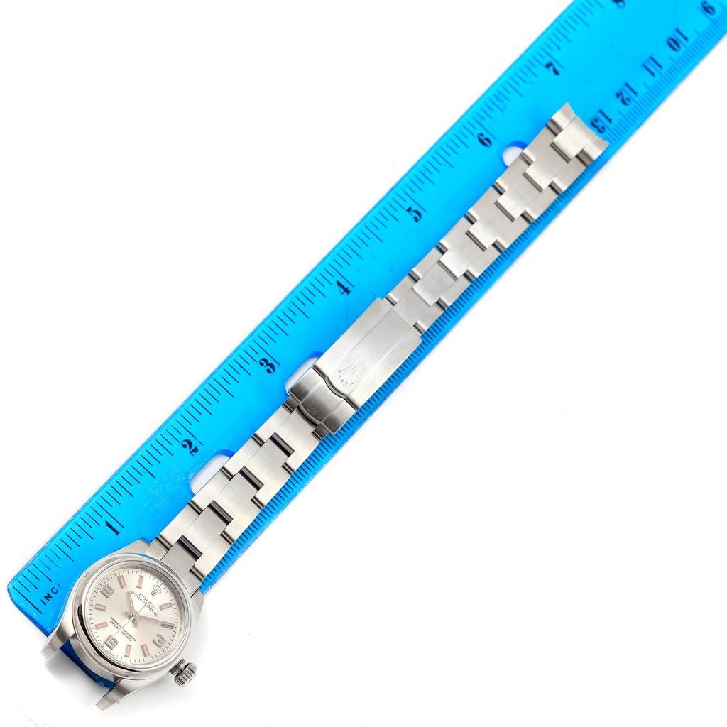 The Rolex Oyster Perpetual 176200 Women
s Stainless Steel Silver Dial 176200 Women
s Stainless Steel Silver Dial watch is shown at a top-down angle with a focus on the bracelet and clasp, placed alongside a ruler.