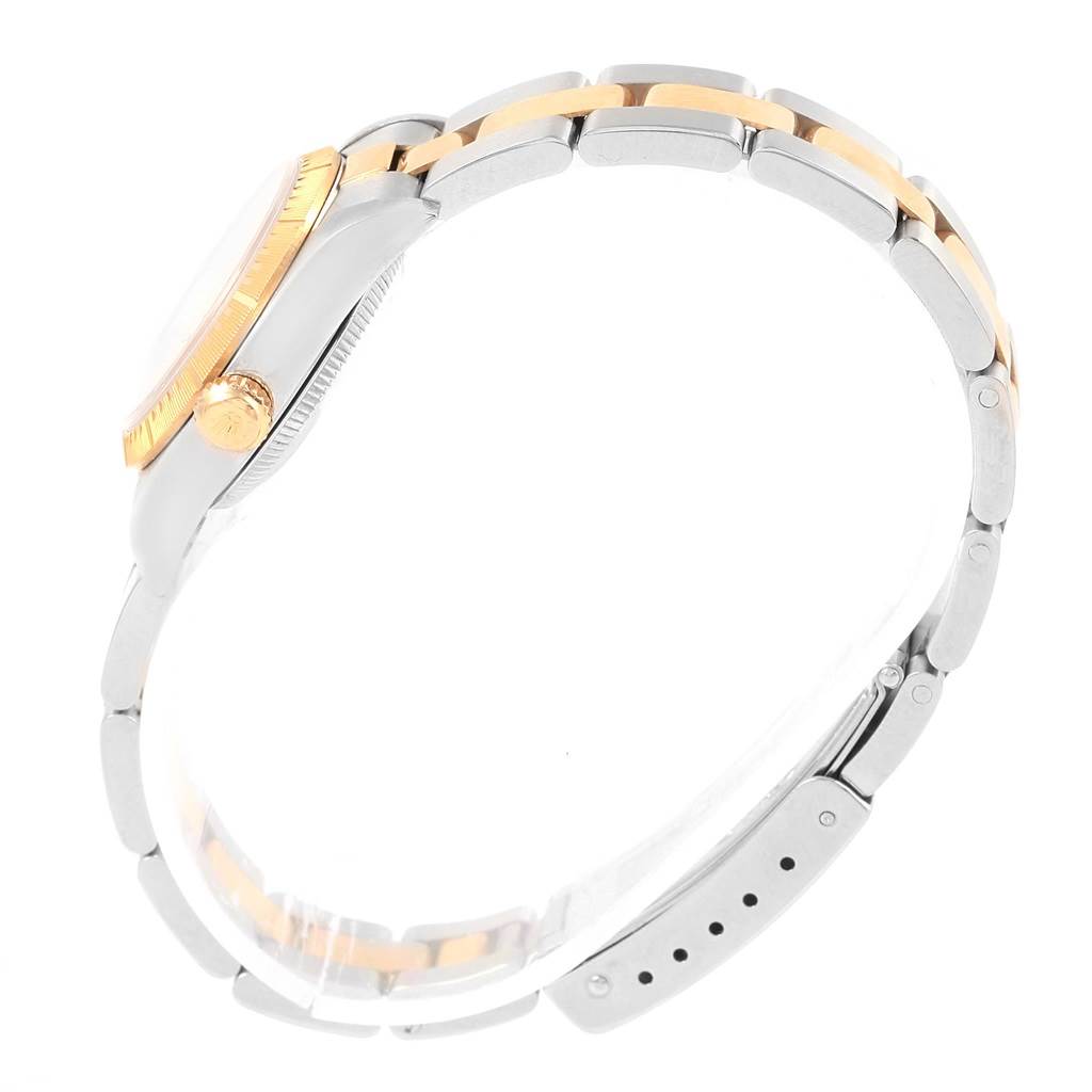 The image shows a side view of a Rolex Oyster Perpetual 76243 Women's Steel and Gold (two tone) Champagne Dial 76243 Women's Steel and Gold (two tone) Champagne Dial watch, highlighting its case, crown, and bicolored bracelet.